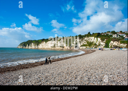 Deux personnes marchant sur la plage de galets sur la côte jurassique au Beer, Devon, England, UK Banque D'Images