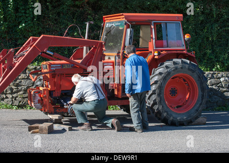 Ouvrier agricole agriculteur ouvrier réparer le tracteur Banque D'Images