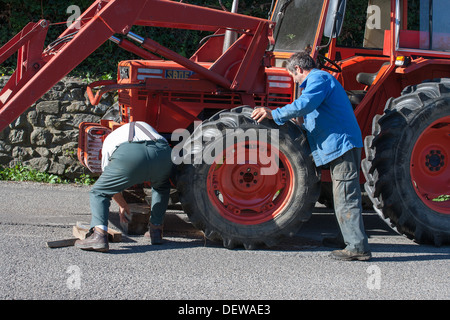 Ouvrier agricole agriculteur ouvrier réparer le tracteur Banque D'Images