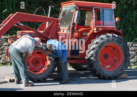 Ouvrier agricole agriculteur ouvrier réparer le tracteur Banque D'Images