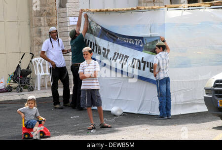 Hébron, en Cisjordanie, en territoire palestinien. 24 août, 2013. Des colons israéliens ont mis en place une affiche lecture en hébreu : ''Nous avons payé et acheté donc c'est la nôtre'' sur une tente de protestation devant la maison du peuple palestinien Abu Rajab, famille, car elles illustrent le 24 septembre 2013 contre l'expulsion des colons de l'immeuble l'année dernière dans la ville de Cisjordanie d'Hébron. Banque D'Images