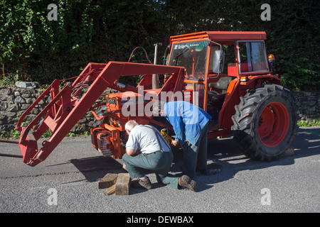 Ouvrier agricole agriculteur ouvrier réparer le tracteur Banque D'Images