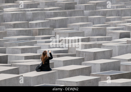 Jeune femme parmi les stèles de béton du Mémorial aux Juifs assassinés d'Europe (Holocaust Memorial), Berlin, Allemagne Banque D'Images