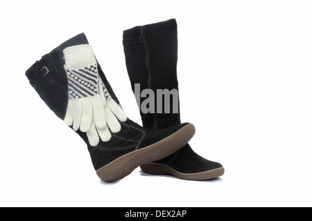 En hiver, des bottes noires et blanches, d'un ornement noir gants. Présenté sur un fond blanc. Banque D'Images