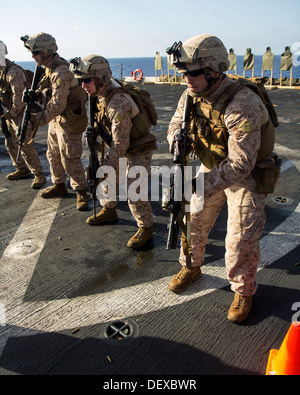Les Marines américains affectés à l'entreprise, l'Équipe de débarquement du bataillon 3/2, 26e Marine Expeditionary Unit (MEU), se préparer à faire feu sur des cibles au cours d'un exercice de tir réel sur le pont de l'USS San Antonio (LPD 17), en mer, le 12 septembre 2013. La 26e MEU est un mari Banque D'Images