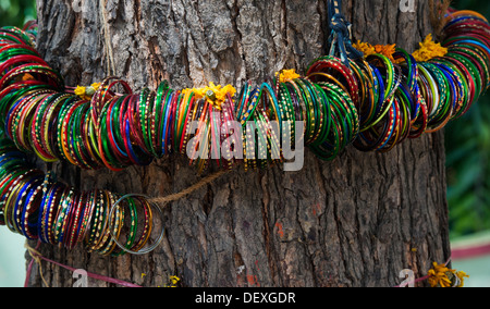 Les indiens colorés chers bangles suspendus autour d'un souhait accomplissement arbre comme offrande sacrée. L'Andhra Pradesh, Inde Banque D'Images
