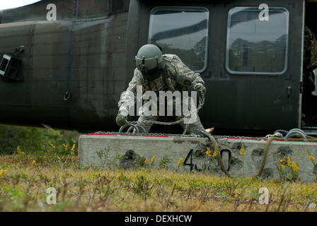 Le Sgt. Dave Gray, chef d'équipe de Dixmont, crochets un livre 4000 bloquer jusqu'à un UH-60 Blackhawk. Il, et d'autres membres du 3e bataillon du 142e Régiment d'aviation, de l'Army National Guard Maine répéter les opérations de charge de l'élingue pour maintenir l'état de préparation à la mission. Un Banque D'Images