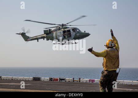 Maître de Manœuvre de l'aviation (manutention) 1re classe Jose Santana dirige un Lynx de la Marine royale britannique MK 8 pour l'atterrissage d'hélicoptère sur le pont d'envol du navire d'assaut amphibie USS Kearsarge (DG 3). Kearsarge est le navire amiral de l'amphibie Kearsarge Banque D'Images