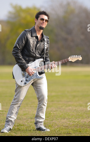 Les jeunes rock musician playing electric guitar outdoor Banque D'Images