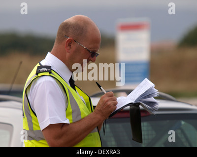 Le Bureau de l'application civile / circulation préfet écrit dans son carnet avant de donner un ticket de parking, Exmouth, Devon, UK 2013 Banque D'Images