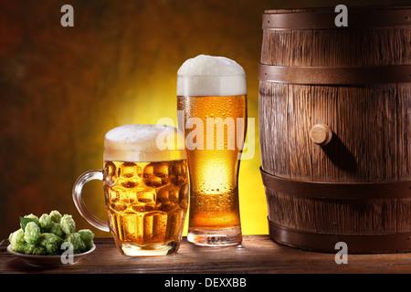 Verres de bière avec un tonneau en bois. Contexte - Jaune foncé dégradé. Banque D'Images