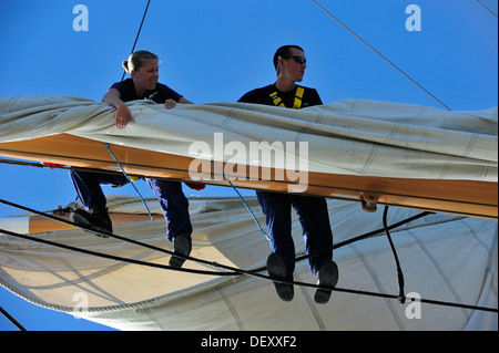 Barque de la Garde côtière canadienne les membres de l'équipage de l'Aigle Maître de 1re classe Melissa Polson et Seaman Joel Sprowls furl voiles sur le chantier Mercredi, 18 Septembre, 2013. L'équipage de l'Aigle trains continuellement cadets et aspirants en matelotage. Banque D'Images