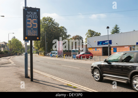 Rouler trop vite, ralentissez signe électronique. Une voiture roulant à dépasser la limite de vitesse comme il passe une vitesse de circulation indicateur d'alerte, England, UK Banque D'Images