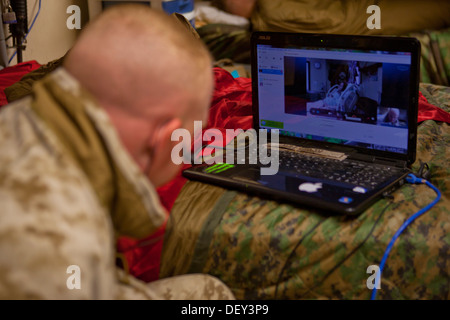 Le Cpl. James s'enregistrer, une logistique de combat avec Marine Regiment 2, Commandement régional (Sud-ouest), regarde son écran d'ordinateur au Camp Sapadalure, province de Helmand, en Afghanistan, au cours de la livraison de son premier enfant 18 Septembre, 2013. S'inscrire vu la naissance Banque D'Images