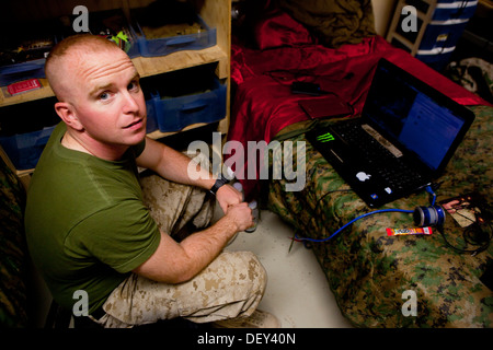 Le Cpl. James s'enregistrer, une logistique de combat avec Marine Regiment 2, Commandement régional (Sud-ouest), attend de son ordinateur pour une session de chat vidéo avec son épouse au Camp Sapadalure, province de Helmand, Afghanistan, le 17 septembre 2013. S'inscrire vu la naissance d'hi Banque D'Images