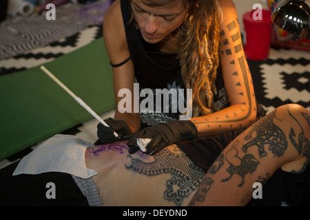 Un tatoueur créer nouveau tatouage à l'aide du traditionnel taraudage manuel au cours de la Convention de Tatouage 2013 à Katowice, Pologne. Banque D'Images