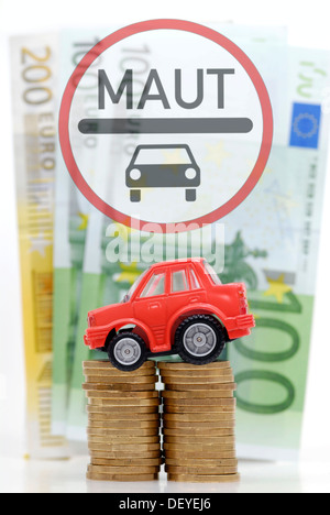 Miniature de voiture sur une pile de pièces, image symbolique pour les péages de voiture Banque D'Images