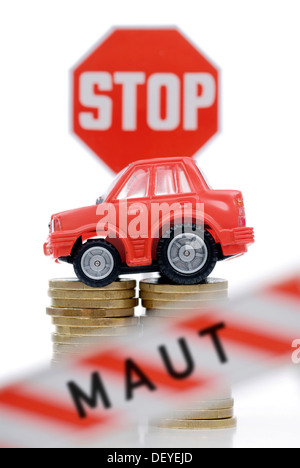 Miniature de voiture sur une pile de pièces, image symbolique pour les péages de voiture Banque D'Images