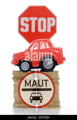 Miniature de voiture sur une pile de pièces, image symbolique pour les péages de voiture Banque D'Images