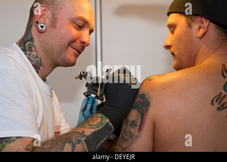 Un tatoueur créer nouveau tatouage lors de la Convention de Tatouage 2013 à Katowice, Pologne. Banque D'Images