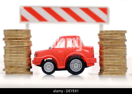 Miniature de voiture entre les piles de jetons, image symbolique pour les péages et taxes voiture Banque D'Images