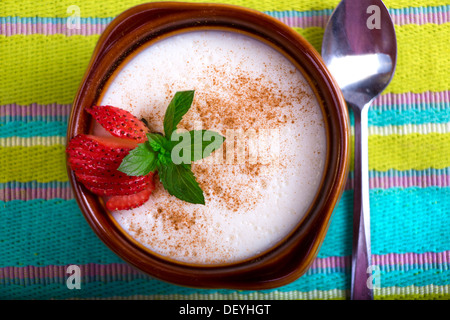 Le style turc riz au lait servi dans une cocotte et garnir de feuilles de menthe et fraise Banque D'Images