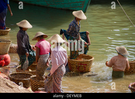 Les femmes stomp et rincer produire sur le fleuve Ayeyarwady à Mandalay, Birmanie. Banque D'Images