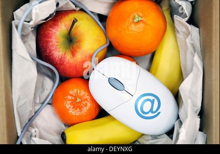 Parcelle avec des fruits et une souris d'ordinateur, image symbolique pour l'épicerie en ligne Banque D'Images