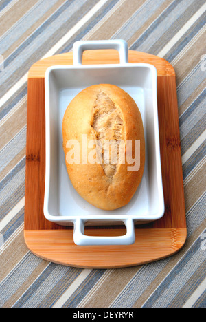 De pain dans un plat allant au four de bois, planche, table cloth rayé Banque D'Images