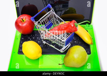 Fruit d'un ordinateur portable par panier, un service d'achat en ligne d'aliments, de Obst auf einem coffre mit Einkaufswagen Onlineshopping, von Lebens Banque D'Images