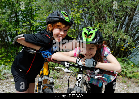 Deux enfants, garçon et fille avec des vtt et des casques. Banque D'Images