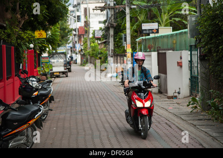 Woman riding a scooter, Chiang Mai, Thaïlande du Nord, Thaïlande, Asie Banque D'Images