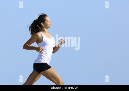 Vue latérale d'une femme fitness courir vite avec le ciel en arrière-plan Banque D'Images