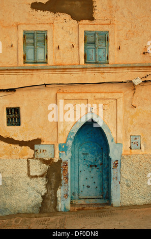 Une façade avec une porte bleue et de forme généralement windows bleu sur un mur blanc à Sidi Ifni, Maroc, Afrique Banque D'Images