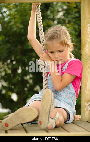 6-year-old girl peur de descendre la corde d'un play house Banque D'Images