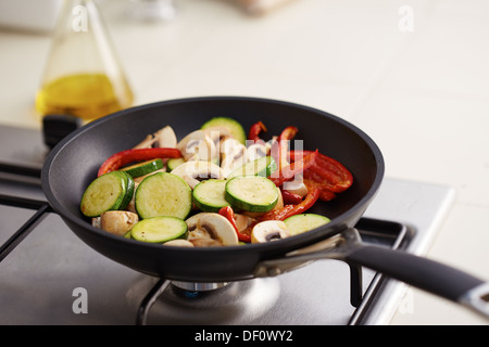 La préparation de légumes grillés tels que les champignons, les poivrons et les courgettes dans une casserole Banque D'Images