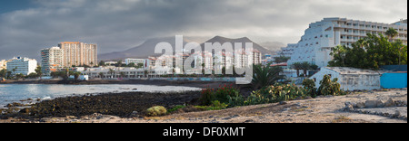 Vieux bâtiments de ferme avec jardin ferme cultivée en premier plan et les bâtiments modernes de Los Cristianos holiday resort en arrière-plan Banque D'Images