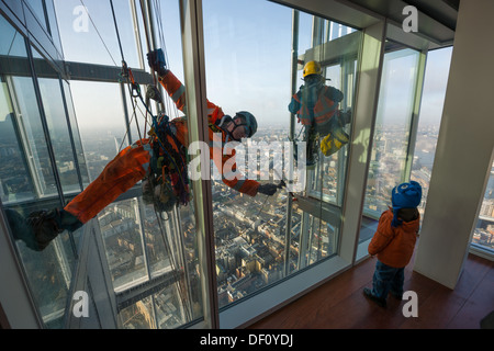 Enfant à la fenêtre à la descente en rappel d'entretien-nettoyage de l'extérieur de la vitre de la vue depuis l'observatoire d'échardes, en haut de la gratte-ciel d'échardes, Londres, Angleterre Banque D'Images