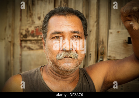 Portrait of male Cuban appuyé contre une porte à la Havane. Banque D'Images