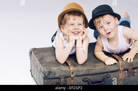 Deux frères mignon allongé sur valises Banque D'Images