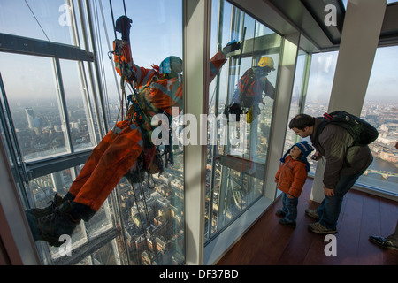 Enfant à la fenêtre à la descente en rappel d'entretien-nettoyage de l'extérieur de la vitre de la vue depuis l'observatoire d'échardes, en haut de la gratte-ciel d'échardes, Londres, Angleterre Banque D'Images