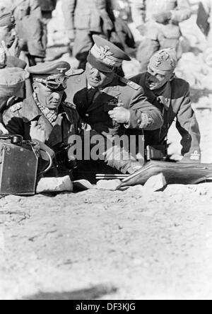 Le maréchal Erwin Rommel (l) s'entretient avec des alliés italiens sur le terrain pendant l'occupation de Tobruk en juillet 1942. La propagande nazie! Sur le dos de l'image est daté du 4 juillet 1942: 'Field Marshal Rommel pendant la planification stratégique dans le désert en Afrique du Nord. Le maréchal Rommel s'entretient avec le chef d'état-major italien Cambara (m) et le général Calvi (r) au sujet de l'emploi de troupes allemandes et italiennes pour suivre l'ennemi en fuite à la frontière égyptienne. Fotoarchiv für Zeitgeschichte Banque D'Images