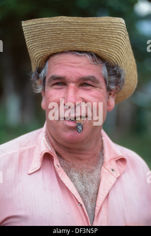 Cuba homme avec un visage rose et portant une chemise rose, fumer un cigare à un rodéo de village dans la ville de Rodas, près de Cienfuegos, Cuba Banque D'Images