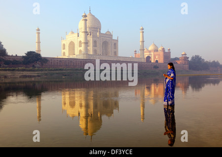 L'Inde, Uttar Pradesh, Agra, Woman wearing blue sari debout à côté du Taj Mahal Banque D'Images