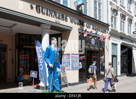 Deux personnes par la figure de l'homme le plus grand du monde à l'extérieur de Guinness World Records museum dans la rue Stroget, Copenhague, Danemark Banque D'Images