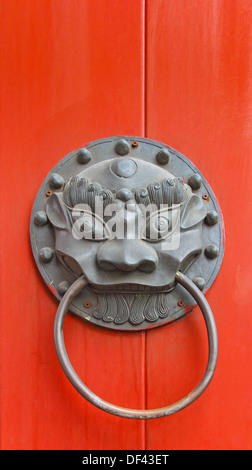 Garnitures pour portes chinois avec une tête de dragon et porte rouge Banque D'Images