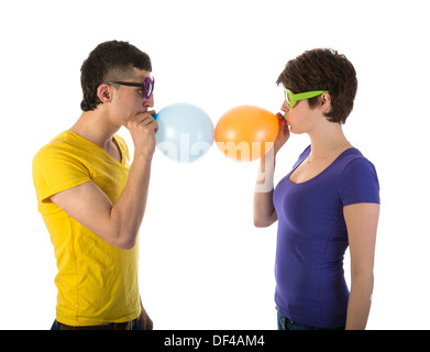 L'homme et de la femme avec des lunettes de ballons de soufflage Banque D'Images