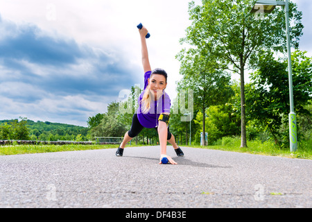 Sports urbains - jeune femme est en train de faire l'échauffement avant l'exécution dans les nouveaux un jour d'été Banque D'Images