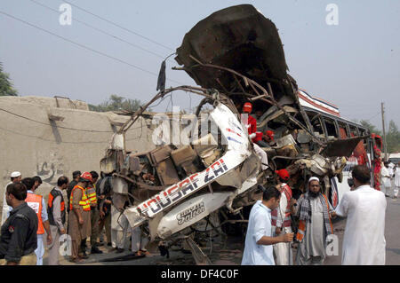 Les fonctionnaires occupés dans recues recues travailler sur le site après une explosion à l'intérieur d'un bus sur la route Charsadda à Peshawar le vendredi 27 septembre, 2013. Environ 19 personnes ont été tuées et 44 autres ont été blessés dans une explosion à l'intérieur d'un bus sur la route de Charsadda. L'attaque visait un bus d'employés du Secrétariat civil qui transportait environ 60 personnes. La bombe avait été placée à l'arrière de l'autobus. Selon l'équipe de neutralisation des bombes (BDS), la bombe contenait environ six à sept kilogrammes d'explosifs et avait un périphérique connecté. L'explosion a été ... Banque D'Images