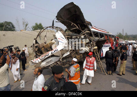 Les fonctionnaires occupés dans recues recues travailler sur le site après une explosion à l'intérieur d'un bus sur la route Charsadda à Peshawar le vendredi 27 septembre, 2013. Environ 19 personnes ont été tuées et 44 autres ont été blessés dans une explosion à l'intérieur d'un bus sur la route de Charsadda. L'attaque visait un bus d'employés du Secrétariat civil qui transportait environ 60 personnes. La bombe avait été placée à l'arrière de l'autobus. Selon l'équipe de neutralisation des bombes (BDS), la bombe contenait environ six à sept kilogrammes d'explosifs et avait un périphérique connecté. L'explosion a été ... Banque D'Images